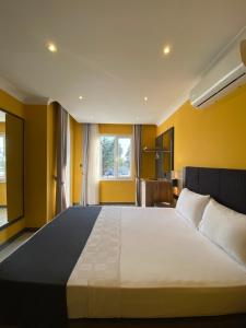 a bedroom with a large bed with yellow walls at Roy Otel in Akçay