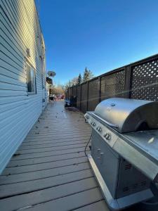 - un barbecue sur une terrasse à côté d'un bâtiment dans l'établissement Van Parys Lake House, à Albert Beach (Alberta)