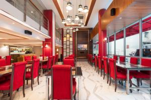 a dining room with red chairs and tables in a restaurant at Khurana Inn in Bangkok