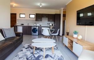a living room with a couch and a table at Comfy 2bed 2bath in a Secure golf estate WIFI in Roodepoort