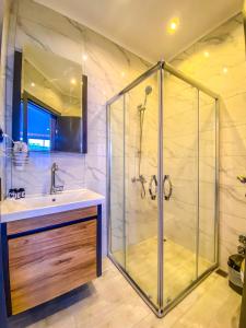 a bathroom with a shower and a sink at Roy Otel Akçay in Akçay