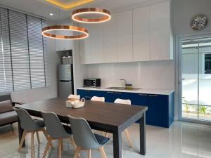 Una cocina con mesa de comedor y sillas. en A Day-Away Pool Villa , Huahin Cha-am, en Ban Phu Wai