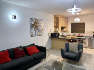 a living room with a couch and a kitchen at Lillys Quarter 1 - Newly Renovated! in Sandton