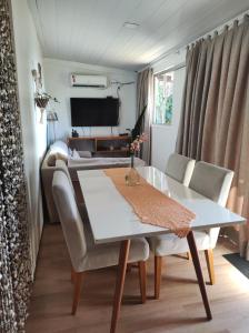Un comedor con una mesa y sillas blancas. en Vida de Ilha, en Fernando de Noronha