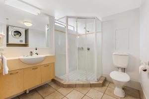 a bathroom with a shower and a toilet and a sink at Coolum Beachside Apartments in Coolum Beach