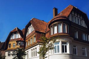 ein großes braunes und weißes Gebäude mit einem Dach in der Unterkunft Villa Otto in Bad Salzuflen