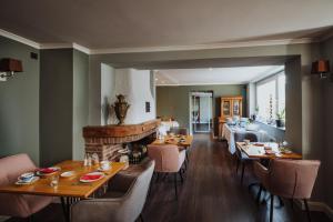 a dining room with tables and chairs and a fireplace at Villa Otto in Bad Salzuflen