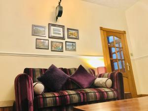 salon z kanapą i fioletowymi poduszkami w obiekcie Station View Lodge Markinch w mieście Markinch
