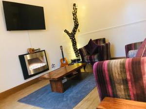 a living room with a couch and a coffee table at Station View Lodge - near Balbirnie House Markinch in Markinch