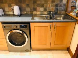 a kitchen with a sink and a washing machine at Station View Lodge - near Balbirnie House Markinch in Markinch