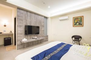 a bedroom with a large bed and a tv on a wall at Secret Garden Homestay in Ji'an