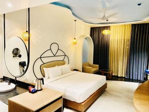 a hotel room with a bed and a table at Ramee Royal Resorts & Spa - Udaipur in Udaipur