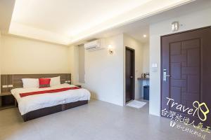 a bedroom with a bed with a red pillow at Secret Garden Homestay in Ji'an