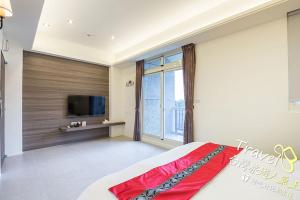 a bedroom with a bed and a tv and a window at Secret Garden Homestay in Ji'an