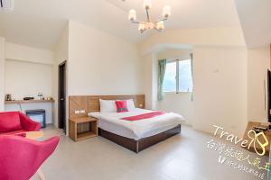 a bedroom with a bed and a red couch at Secret Garden Homestay in Ji'an