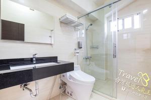 a bathroom with a toilet and a glass shower at Secret Garden Homestay in Ji'an