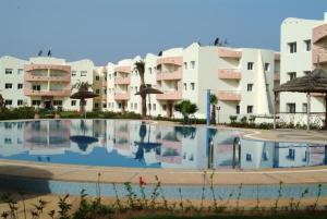 a large swimming pool in front of some apartment buildings at Mohammedia 18 in Mohammedia