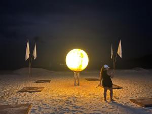 a woman standing on a beach with umbrellas at Tommy Resort in Haad Rin