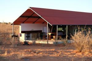 a building with a red roof in the desert at Kalahari Anib Camping2Go in Mariental