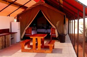 a tent with a table and a bed in it at Kalahari Anib Camping2Go in Mariental