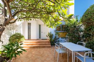 een patio met een tafel en stoelen en een boom bij La Rosa Home in Torremolinos