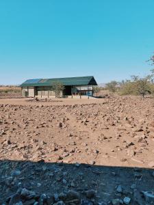 a building in the middle of a dirt field at Palmwag Camping2Go in Kamanjab
