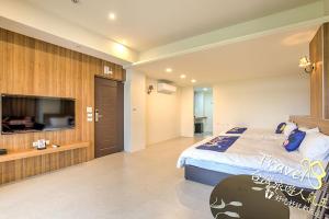 a bedroom with a large bed and a flat screen tv at Secret Garden Homestay in Ji'an