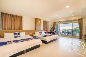 a hotel room with two beds and a balcony at Secret Garden Homestay in Ji'an
