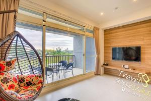 a room with a balcony with a couch and a tv at Secret Garden Homestay in Ji'an
