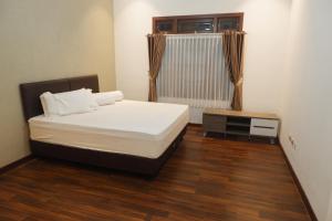 ein Schlafzimmer mit einem großen Bett und einem Fenster in der Unterkunft AINUN VILLA DIENG in Banjarnegara