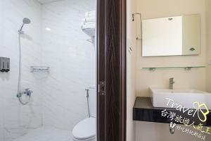 a bathroom with a toilet and a sink and a mirror at Secret Garden Homestay in Ji'an