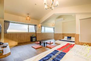 a bedroom with two beds and a table in it at Secret Garden Homestay in Ji'an