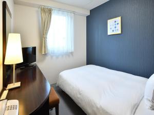 a hotel room with a bed and a desk with a computer at Chisun Hotel Koriyama in Koriyama