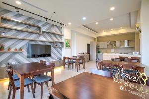 a dining room with tables and chairs and a tv at Secret Garden Homestay in Ji'an