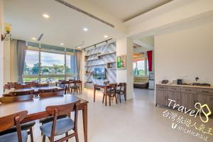 a dining room with tables and chairs and a kitchen at Secret Garden Homestay in Ji'an
