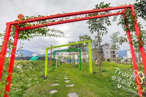 a red and yellow archway in a field at Secret Garden Homestay in Ji'an