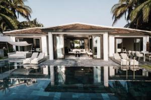 a villa with a pool in front of a house at TIA Wellness Resort - Spa Inclusive in Da Nang