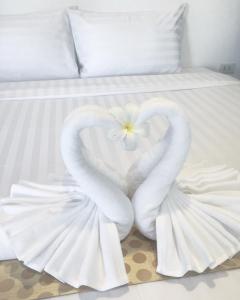 two swans forming a heart on a bed at The Cosy Maenam Beach Resort in Mae Nam