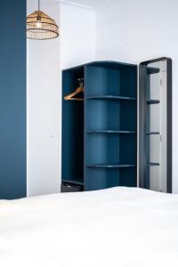 une armoire bleue dans une pièce avec un miroir dans l'établissement Beverly Hills Hotel, à Bruxelles