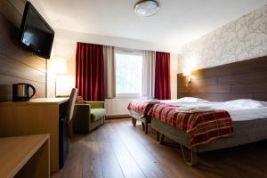 a hotel room with two beds and a television at Lapland Hotels Sirkantähti in Levi