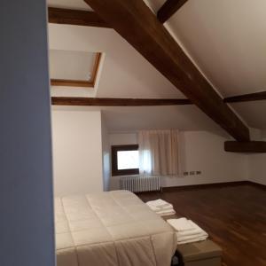 una camera con letto in una stanza con soffitti in legno di Alloggio Cantalupo a Formigine
