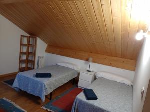 Habitación con 2 camas y techo de madera. en Pico la Selva, en Villanúa
