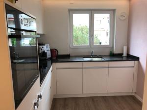 eine Küche mit einem Waschbecken und einem Fenster in der Unterkunft Ferienwohnung Rapperswil in Rapperswil-Jona