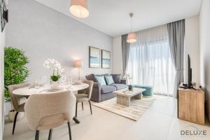 uma sala de estar com uma mesa e um sofá em Sublime 1BR at The Address Residences in JBR by Deluxe Holiday Homes em Dubai