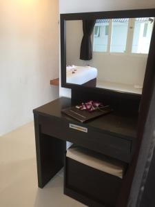 a black dresser with a mirror on top of it at The Cosy Maenam Beach Resort in Mae Nam