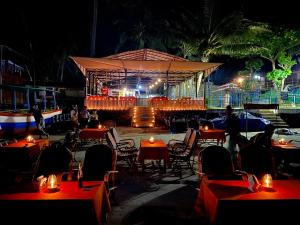a restaurant with tables and chairs in front of a stage at Chill Out Jasmine Restaurant Bar Rooms in Palolem