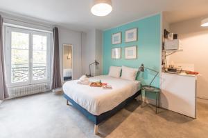 um quarto com uma cama com uma parede azul em Apartments WS Mouffetard - Panthéon em Paris