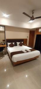 a bedroom with a large bed with a ceiling fan at Aditya Inn in Guwahati
