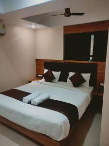 a bedroom with a large bed with black and white pillows at Aditya Inn in Guwahati