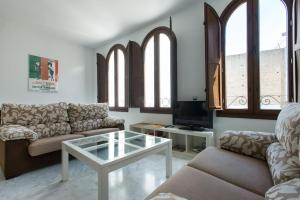 Sala de estar con 2 sofás y mesa de centro en Bustos Tavera, en Sevilla